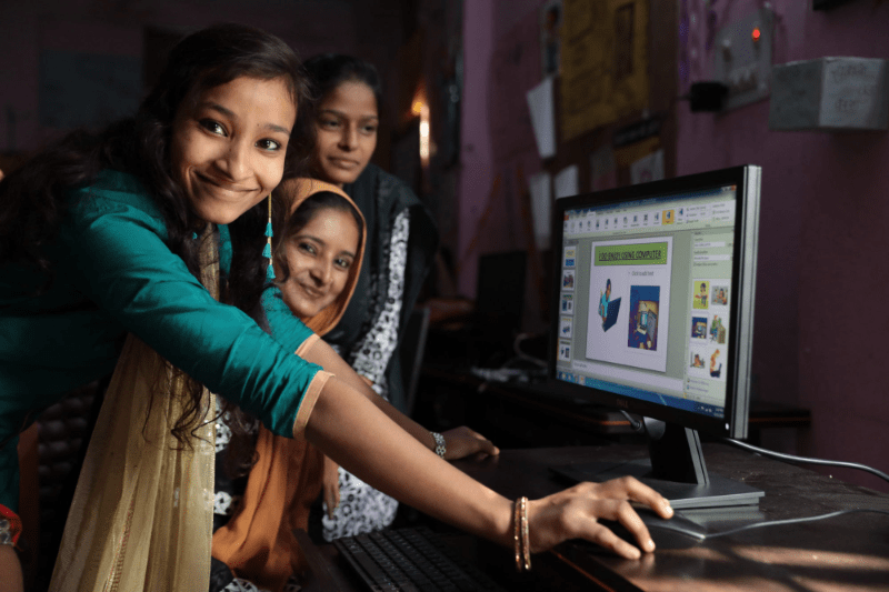 Filles dans une salle de classe travaillant sur un ordinateur