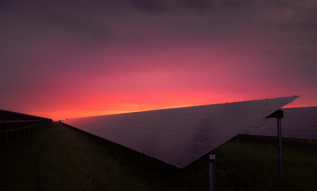 Red sunset over a solar farm