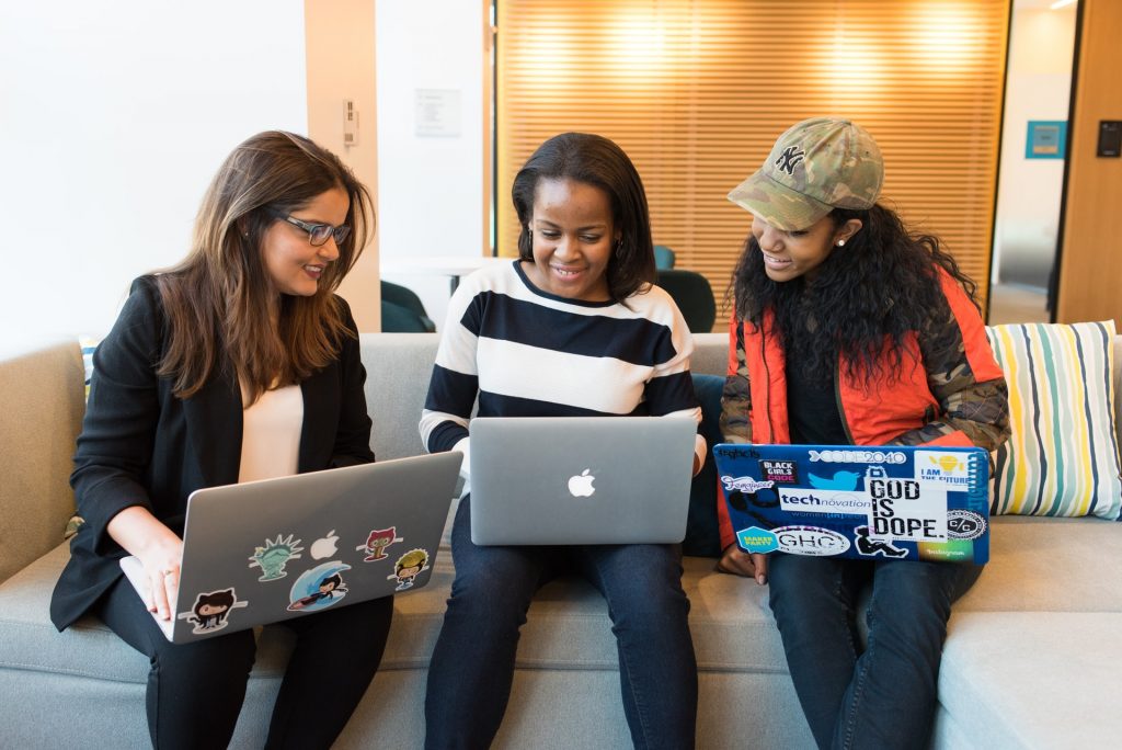 Three women working together on laptops