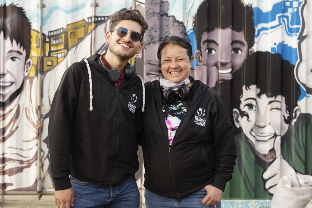 Photo of man and woman standing in front of a mural