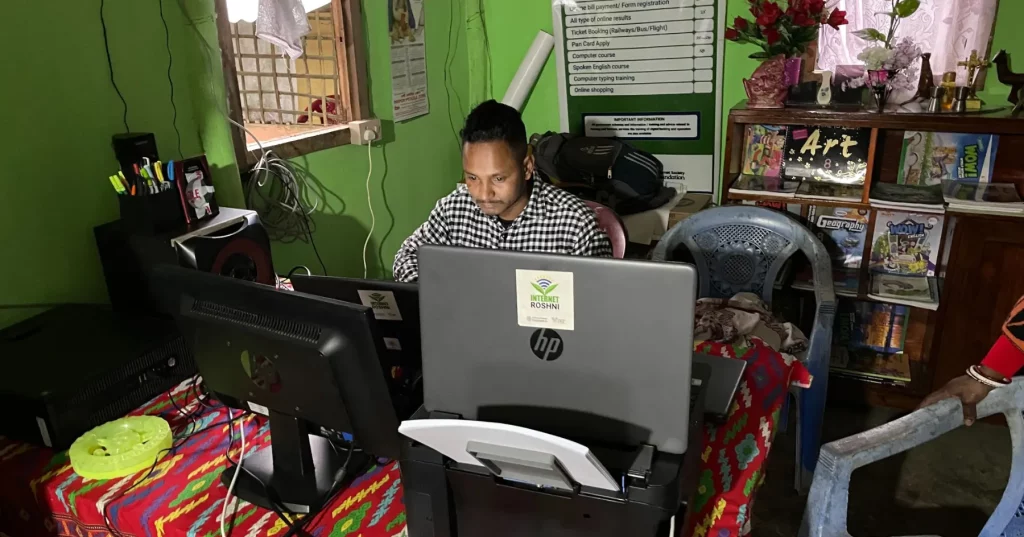 Man sits at computer screens in an office in India