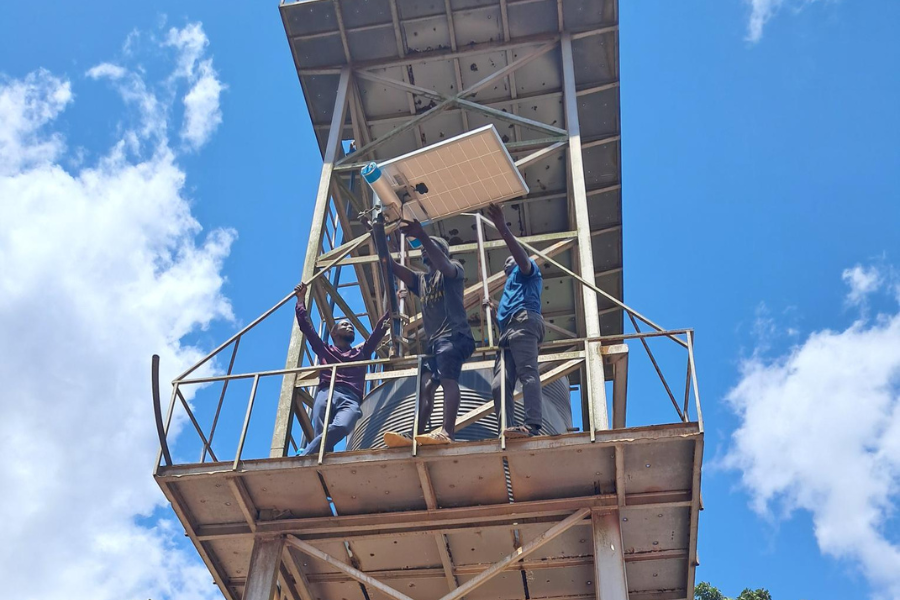 Three men in a tower are assembling Internet infrastructure.
