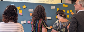Group of people brainstorming and putting sticky notes on a wall.