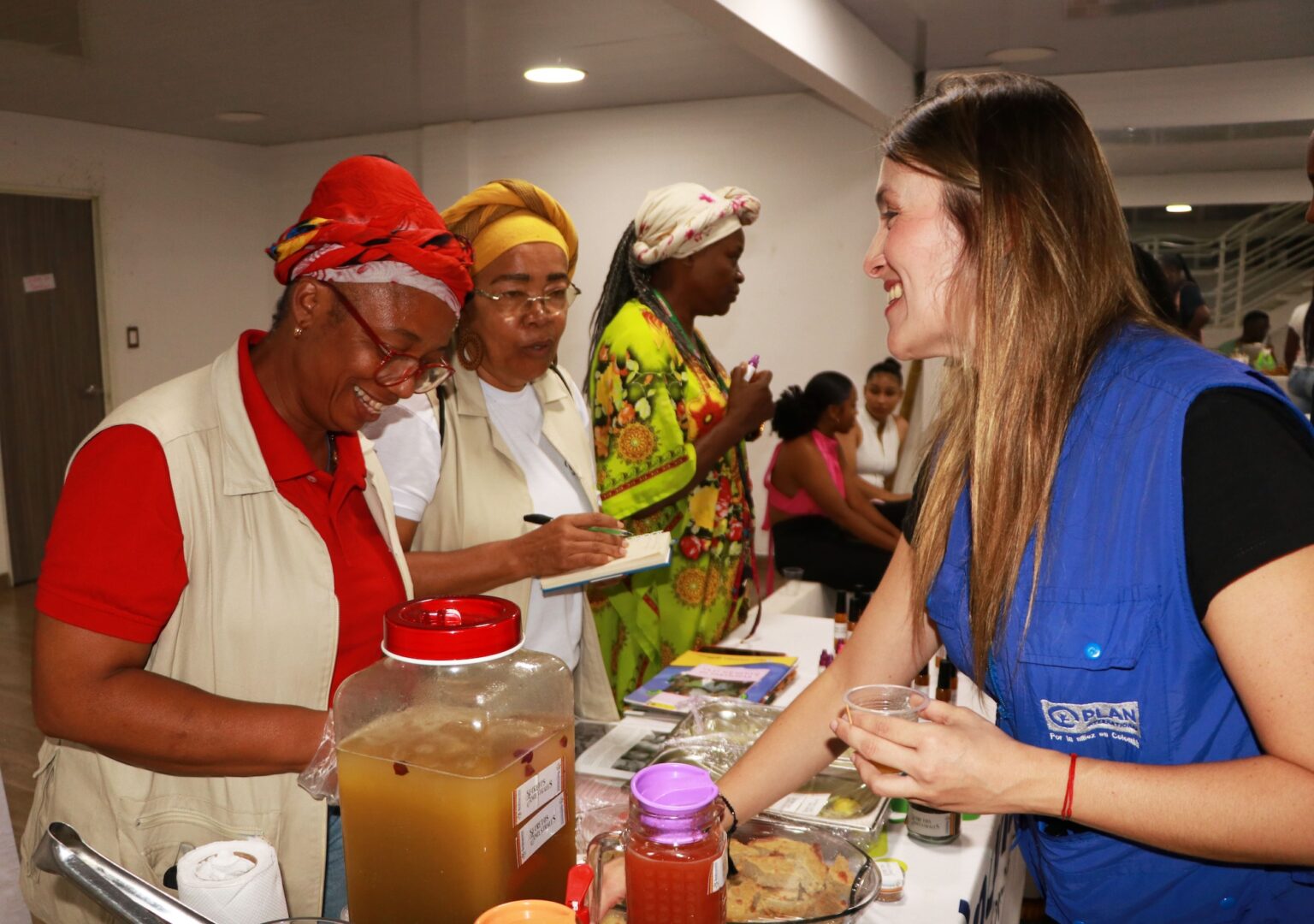 A man in a black shirt sits at a table, working on a laptop.