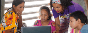 A woman and three children are interacting with a laptop.