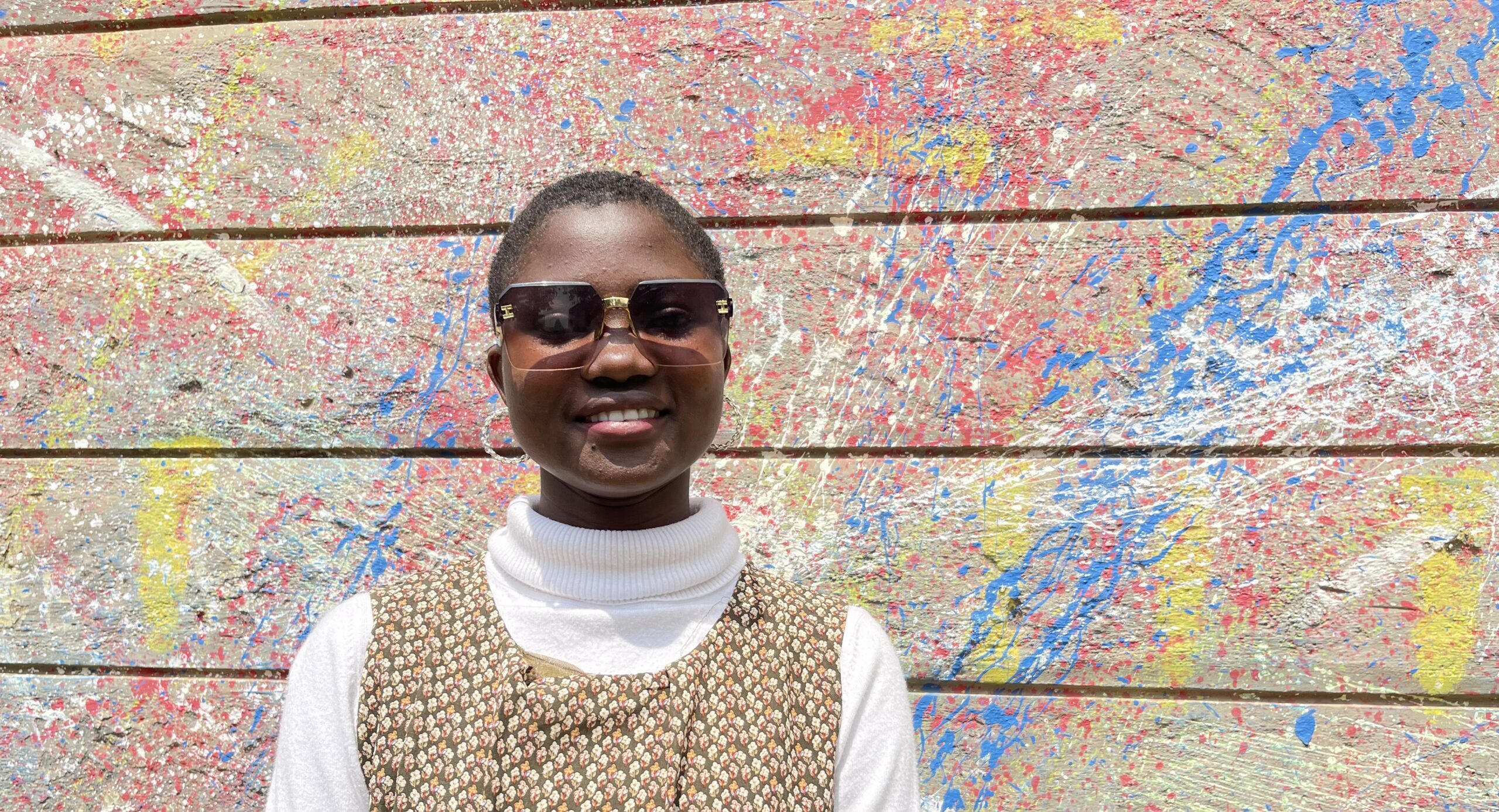 African Girl posing for a photo against a wall