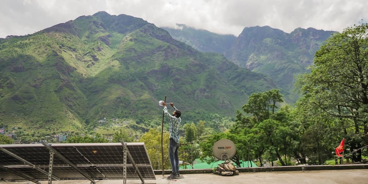 A man assembles an Internet device in a mountain.