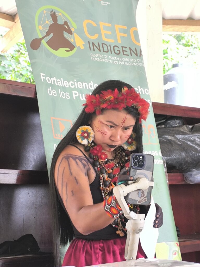 An Indigenous woman is using the phone for a video call.