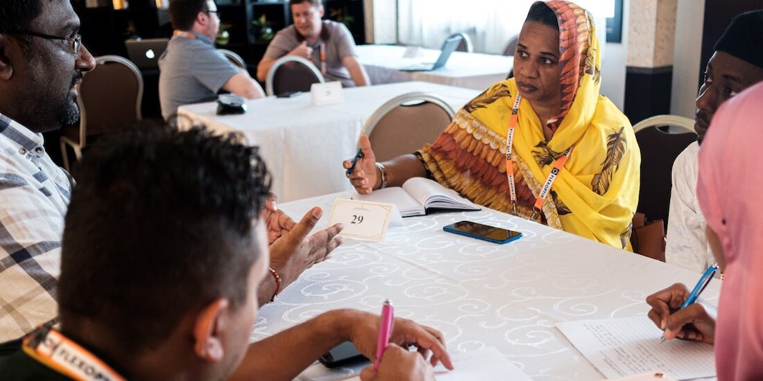 Delegates sit around a conference table