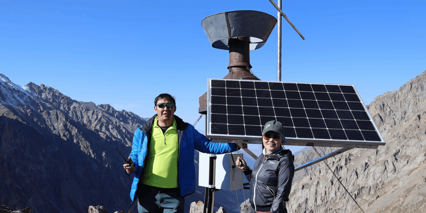 A man and a woman are on the top of a mountain showing Internet infrastructure.
