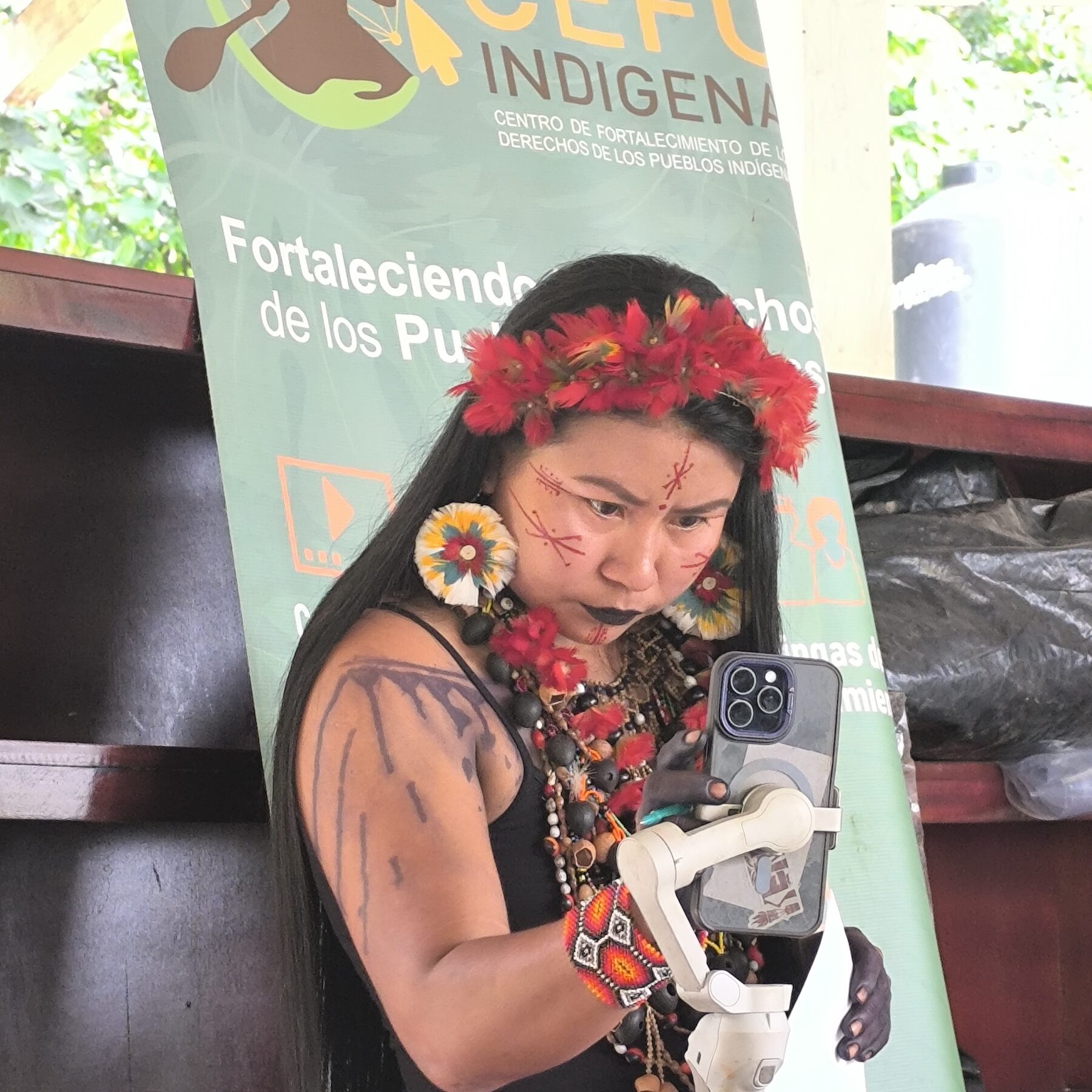 An Indigenous woman is using the phone for a video call.