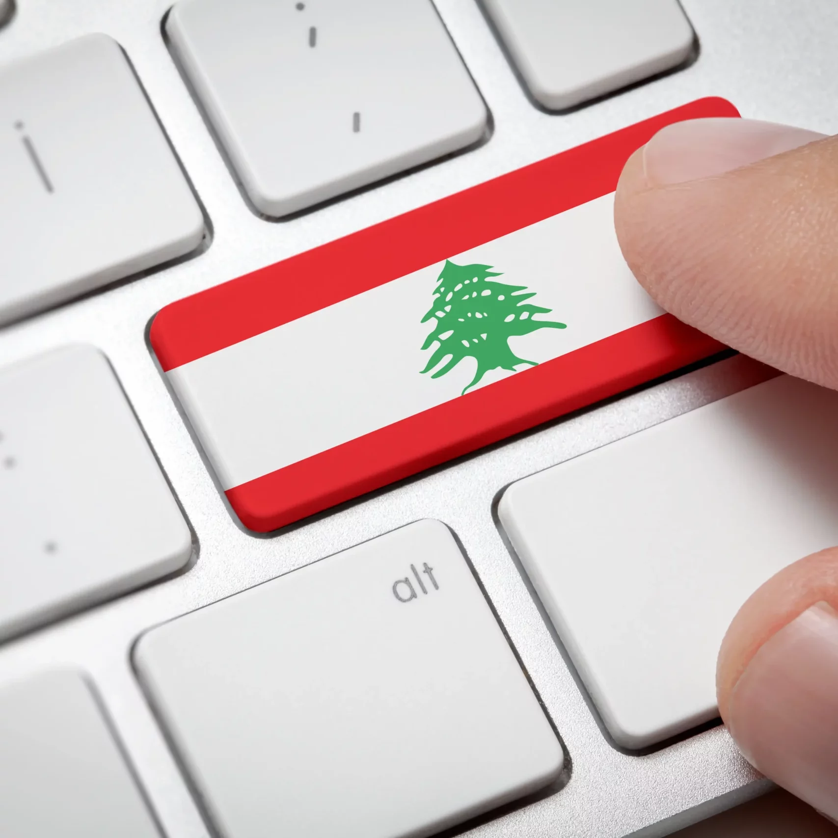 Online International Business concept: Computer key with the Lebanon on it. Male hand pressing computer key with Lebanon flag.