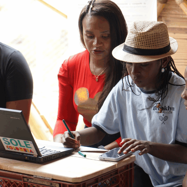 A group of young people works on a laptop.