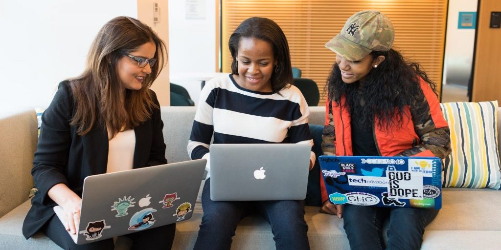 Three women working together on laptops